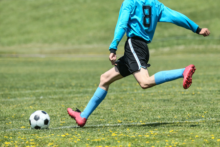 腰椎分離症の原因の腰を反り捻じるサッカーのボールを蹴る写真