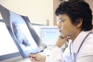 脊柱管狭窄症治療の整骨院「宮谷小交差点前せいこついん」の脊柱管狭窄症のレントゲン写真を見ている医者イメージ